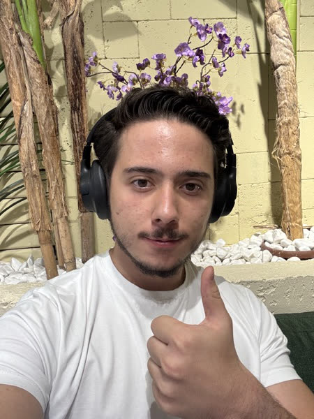 Göktürk wearing headphones and giving a thumbs-up.