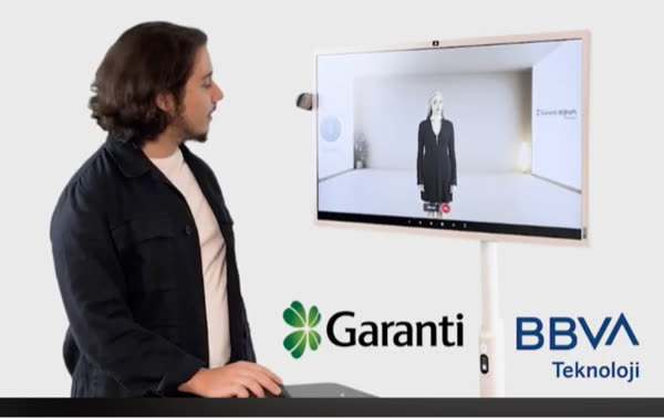 Nova Replica avatar shown on a display during a presentation with Garanti BBVA Teknoloji signage.